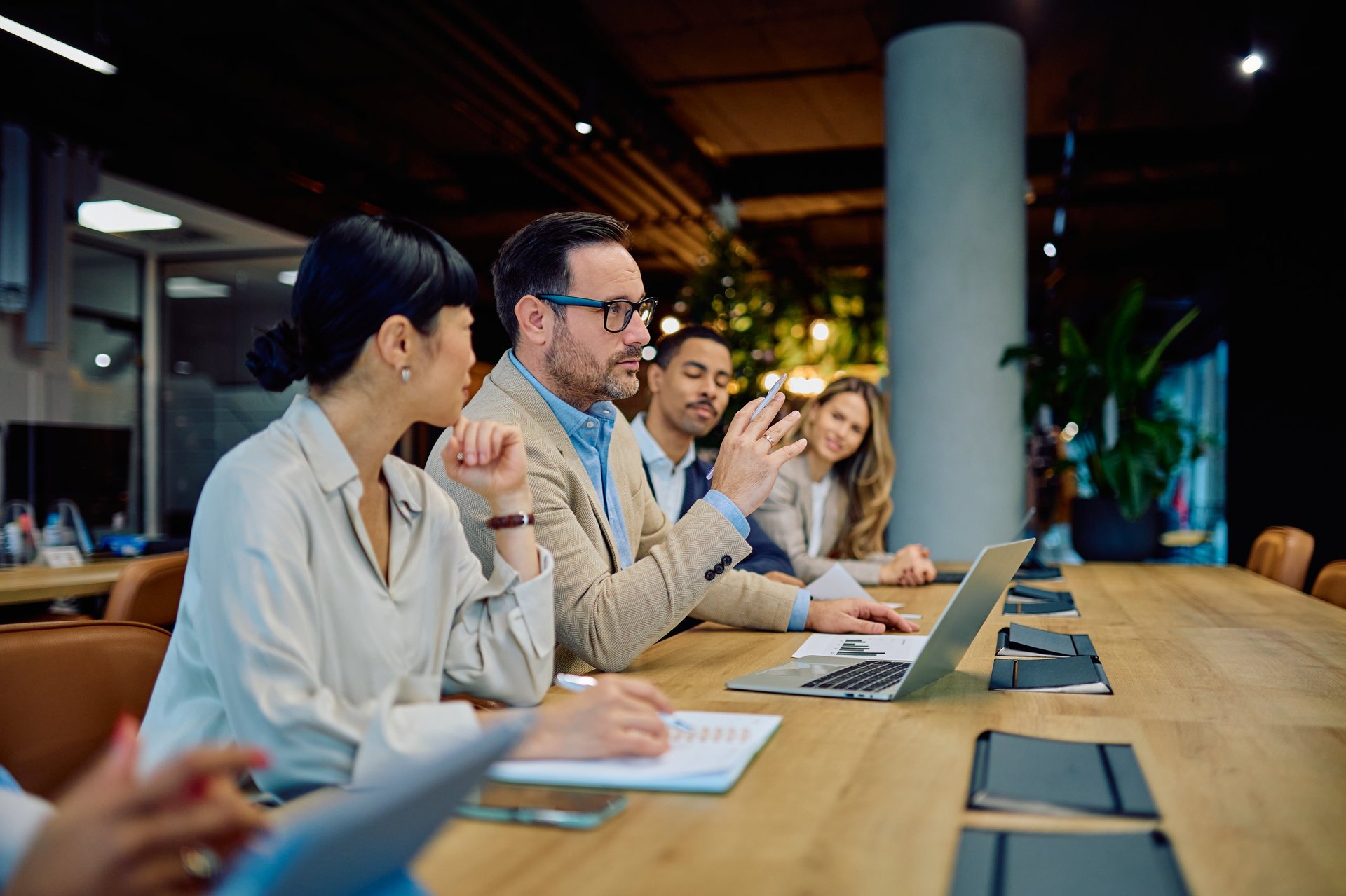 Business professionals engaging in a meeting, discussing strategy and ideas, reflecting teamwork and communication in the office